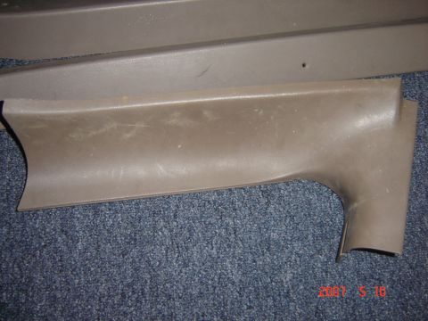 1993 Ford Bronco - A close-up view of a brown plastic interior trim piece, possibly from a vehicle's dashboard or door panel.
