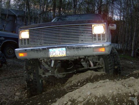 1982 Chevrolet C/K Pickup - This lifted pickup truck, likely from the early 1980s, is shown from the front, navigating rough terrain.
