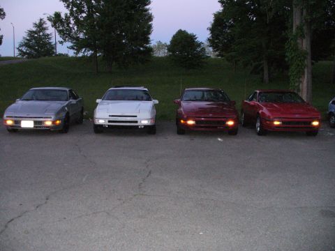 1991 Ford Probe - Four Ford Probe cars are parked in a lot at dusk.