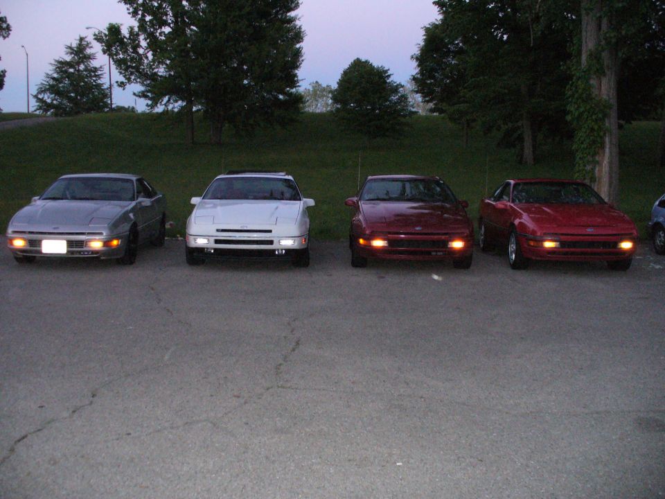 Four 1991 Ford Probes parked in a row, two red, one white, one silver