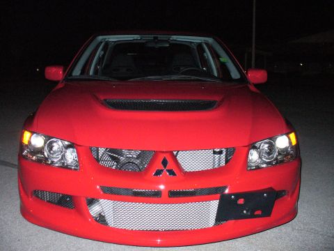 1991 Ford Probe - This red Mitsubishi Lancer Evolution features a distinctive front grille and hood scoop, indicating a model year around 2003.