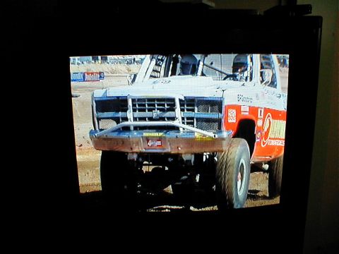1996 Ford Bronco - This off-road racing truck features a prominent grille, custom bumper, and racing decals.