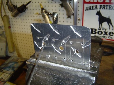 1989 Ford Bronco - A metal plate is being worked on in a vise, with tools visible in the background.