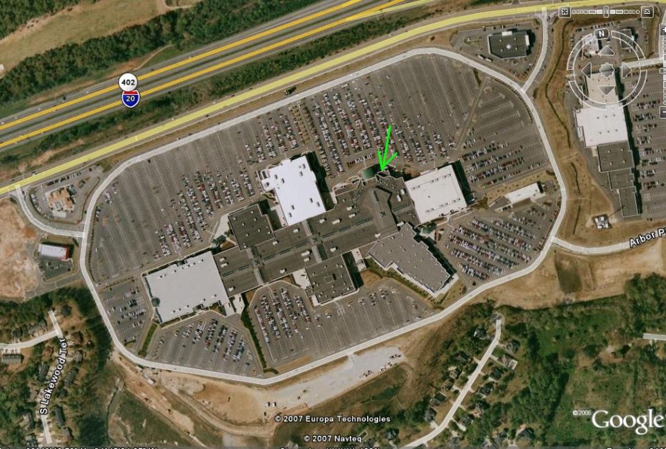 Aerial view of a large mall parking lot with many cars and a highway nearby