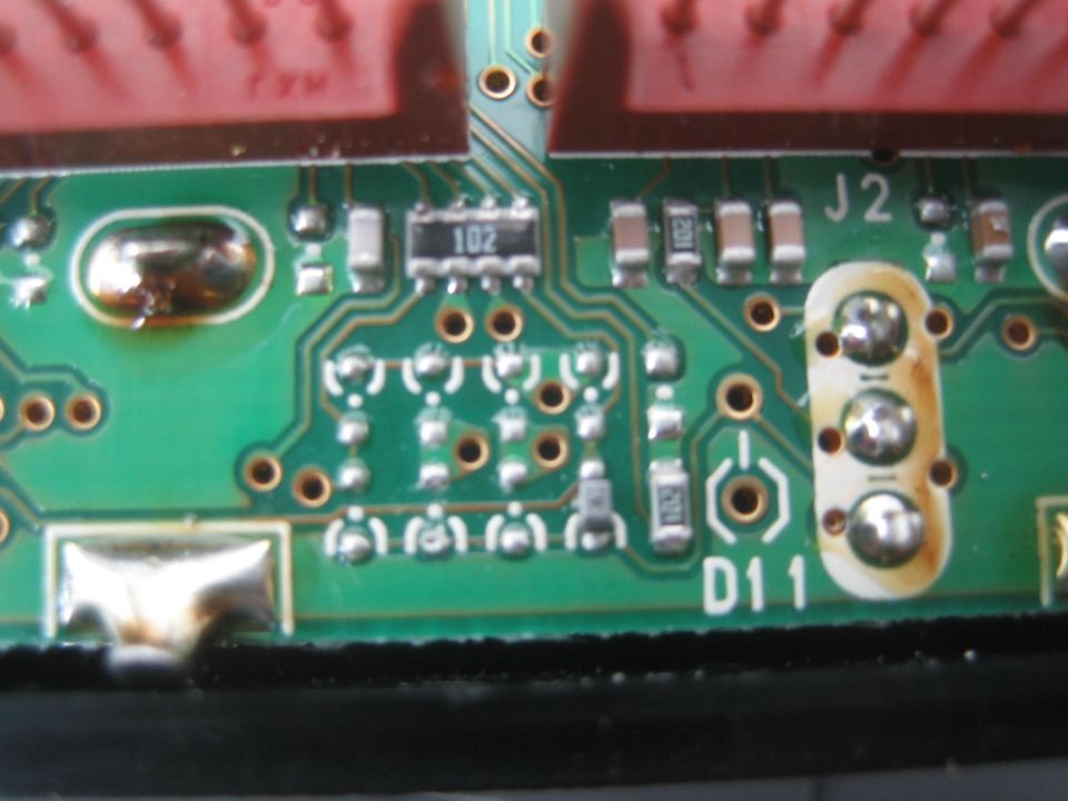 Close-up of green PCB with components labeled J2 and D11