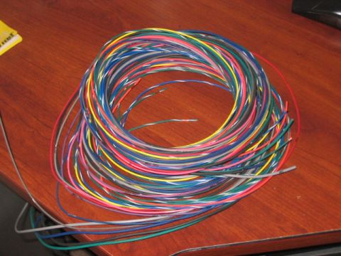 1991 Ford Bronco - A large coil of multi-colored electrical wires is spread out on a wooden desk.