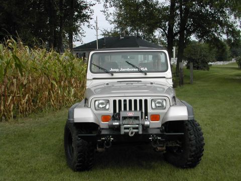 1998 Ford Crown Victoria - A silver Jeep Wrangler is parked on a grassy lawn with corn stalks in the background.