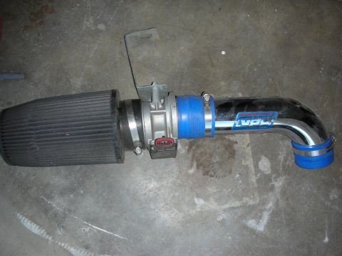 1998 Ford Crown Victoria - polished cold-air intake tube with a black cone filter, mass-air housing, and blue silicone couplers on a floor.