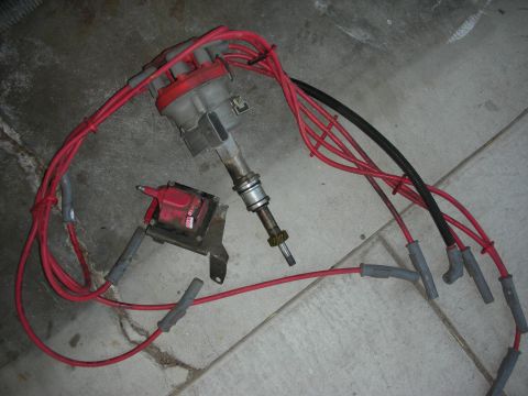 1998 Ford Crown Victoria - A set of ignition parts, including a distributor and coil, are shown with red spark plug wires.