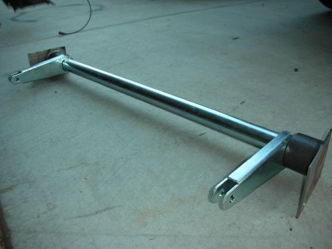 1998 Ford Crown Victoria - A metal suspension component, likely for a vehicle, is shown on a concrete surface.