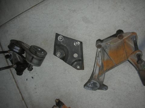 1998 Ford Crown Victoria - Various metal automotive components are laid out on a gray concrete floor.