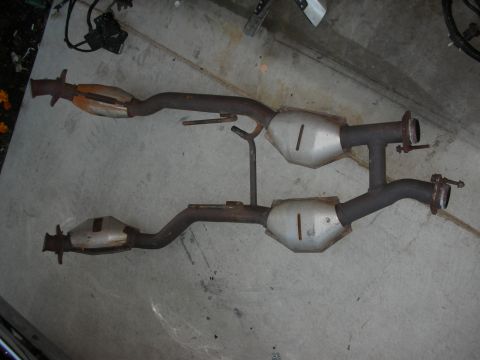 1998 Ford Crown Victoria - Dual catalytic converter exhaust system, likely from a V8 engine, shown on a concrete surface.