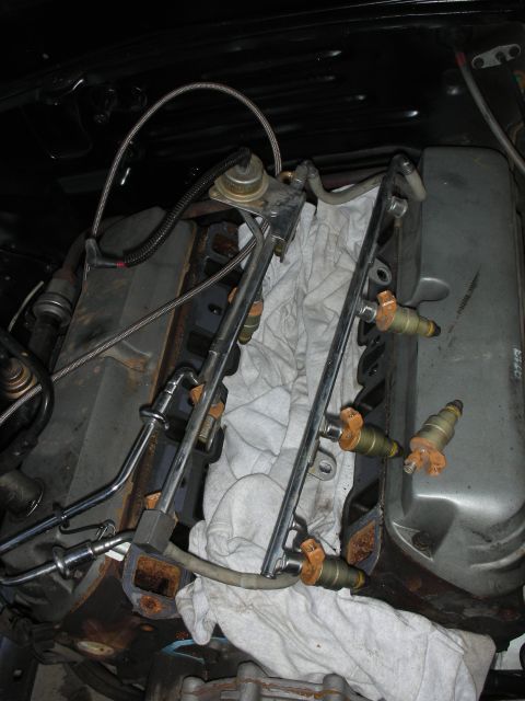 1998 Ford Crown Victoria - Close-up view of fuel injectors and fuel rail assembly, likely during engine maintenance or repair.