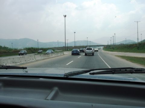 1995 Ford F-150 - Driving on a highway with multiple vehicles on the road and mountains in the background.