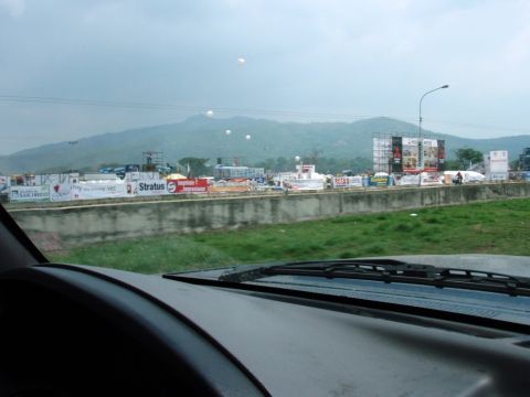 1995 Ford F-150 - Roadside scene with billboards and mountains, viewed from inside a vehicle.