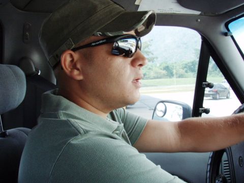 1995 Ford F-150 - Interior view of a man driving a 1995 Ford F-150, with another car visible in the background.