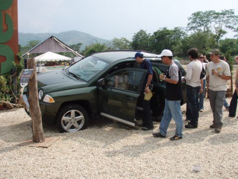 1995 Ford F-150 - A group of people gather around a green SUV parked in a gravel lot.