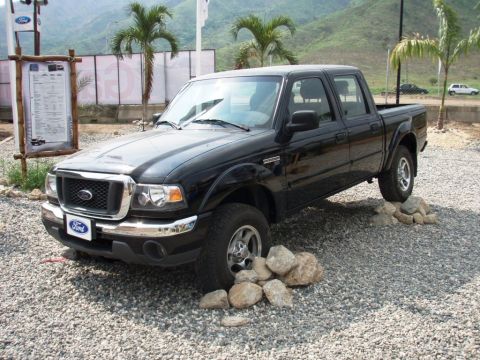 1995 Ford F-150 - A black Ford Ranger pickup truck is parked on a gravel lot with rocks under its tires.
