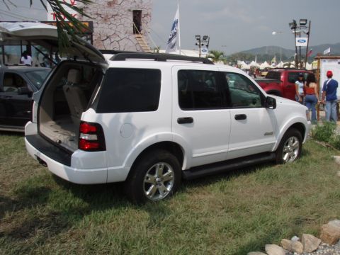 1995 Ford F-150 - White Ford Explorer SUV with its rear hatch open, parked outdoors with a red Ford pickup in the background.