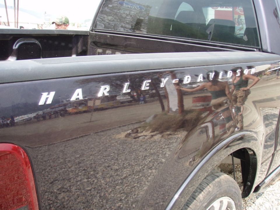 Side view of a dark pickup truck with Harley-Davidson badging on the fender