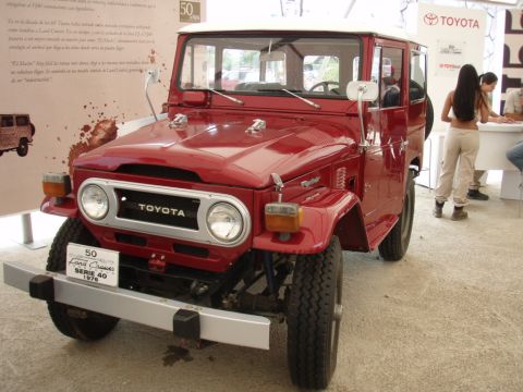 1995 Ford F-150 - Front view of a red Toyota Land Cruiser FJ40, identified by a badge as a 1976 model.