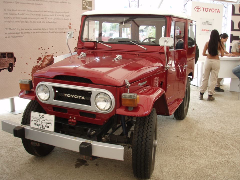 Red Toyota Land Cruiser FJ40 with '50 Land Cruiser Serie 40 1976' badge on front bumper