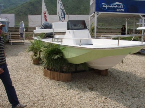 1995 Ford F-150 - A boat is displayed outdoors with promotional flags and foliage around it.