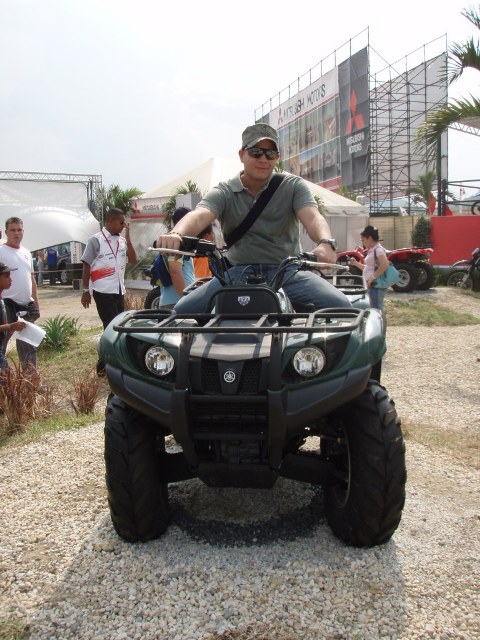 1995 Ford F-150 - A man rides a green ATV in an outdoor event setting with other ATVs visible.