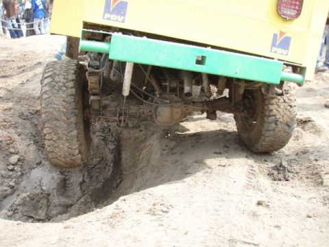 1995 Ford F-150 - This off-road vehicle is stuck in the mud, showing its rear axle and large tires.