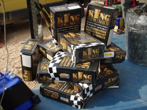 1995 Ford F-150 - Boxes of King Springs are stacked on a blue tarp, with a yellow vehicle partially visible in the background.