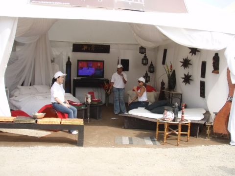 1995 Ford F-150 - A tent is set up with furniture and a television, with three people inside.