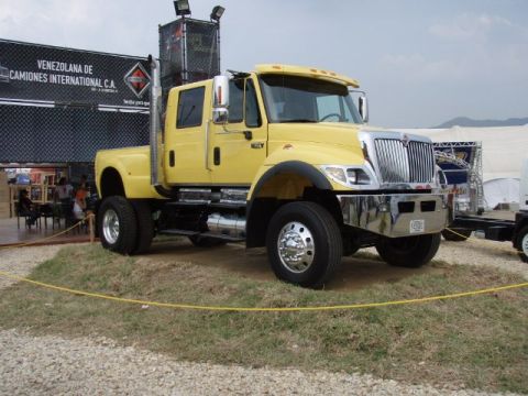 1995 Ford F-150 - A yellow International truck is displayed outdoors with a large banner in the background.