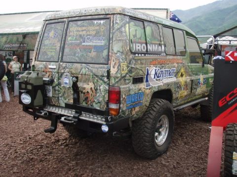 1995 Ford F-150 - This camouflaged SUV features a rear-mounted spare tire carrier and a jerry can, suggesting it is prepared for off-road adventures.