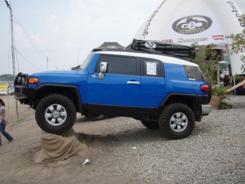 1995 Ford F-150 - This blue Toyota FJ Cruiser with a white roof is displayed at an outdoor event.