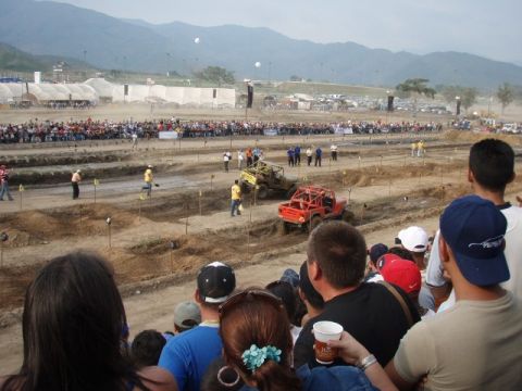 1995 Ford F-150 - Spectators watch as off-road vehicles navigate a challenging course during a competition.