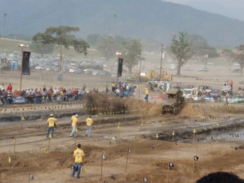 1995 Ford F-150 - Spectators watch as vehicles participate in a mud bogging event on a dirt track.