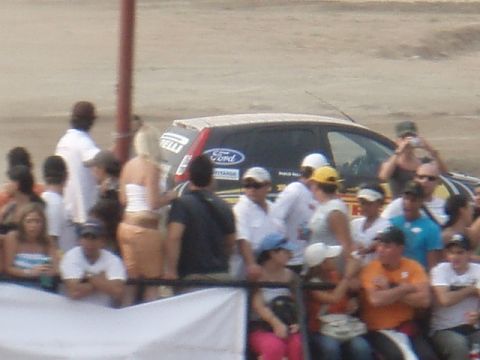 1995 Ford F-150 - A Ford Focus hatchback with racing decals is visible behind a crowd of spectators.