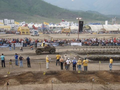 1995 Ford F-150 - Outdoor 4x4 competition course lined with dirt whoops and yellow marker flags, where an olive-drab open-top military-style Jeep runs the tr…