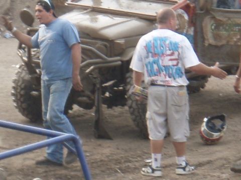 1995 Ford F-150 - Two men are near a muddy off-road vehicle, with a helmet on the ground.