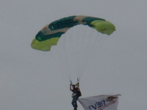 1995 Ford F-150 - A skydiver descends under a colorful parachute, holding a banner with text.