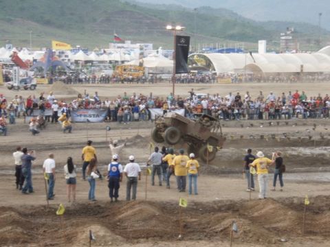 1995 Ford F-150 - An off-road vehicle is captured mid-air during a competition event with a crowd watching.