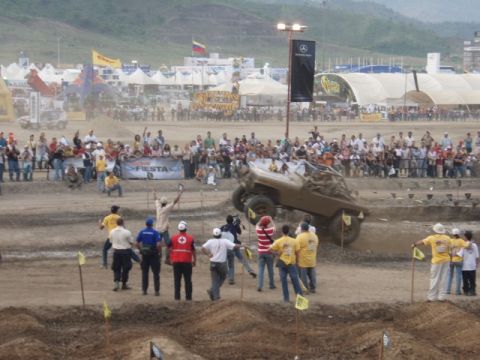 1995 Ford F-150 - A crowd watches as a modified off-road vehicle navigates a challenging course during an event.