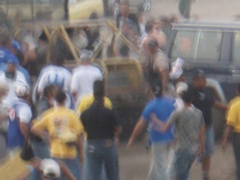 1995 Ford F-150 - A crowd of people surrounds a dark-colored SUV in this blurry photograph.