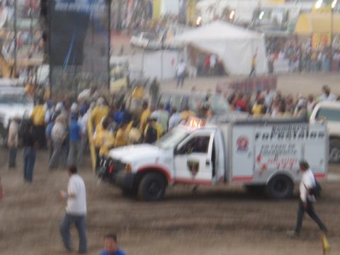 1995 Ford F-150 - A white truck with emergency lights is parked in front of a crowd at an outdoor event.