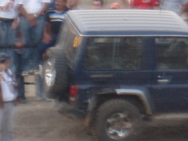 Dark blue SUV with spare tire on rear, side view