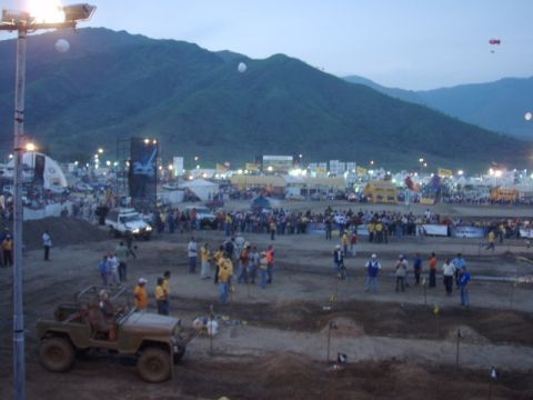 1995 Ford F-150 - An outdoor event with spectators and various vehicles under a dusky sky.