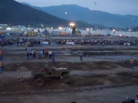 1995 Ford F-150 - An off-road event is underway with a jeep navigating a dirt track as crowds watch.