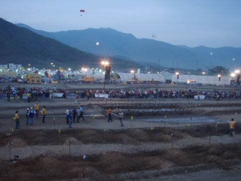 1995 Ford F-150 - A wide view of an outdoor event with tents and spectators under a twilight sky.