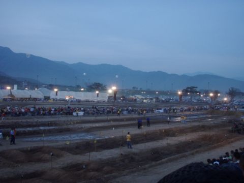 1995 Ford F-150 - An outdoor event unfolds at dusk, with tents, spectators, and mountains forming the backdrop.