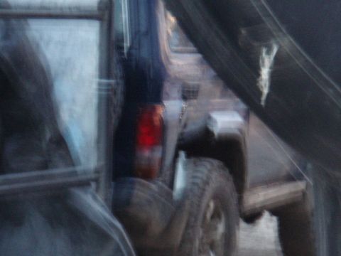 1995 Ford F-150 - Blurry photo of the rear of a dark truck, with a visible taillight and tire.